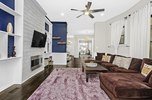4738 S Champlain Ave, Chicago, IL 60615 - living room featuring wood finished floors, a ceiling fan, built in shelves, a large fireplace, and a decorative wall