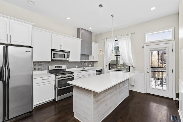 4738 S Champlain Ave, Chicago, IL 60615 - kitchen with stainless steel appliances, a sink, dark wood-type flooring, white cabinets, and a wainscoted wall