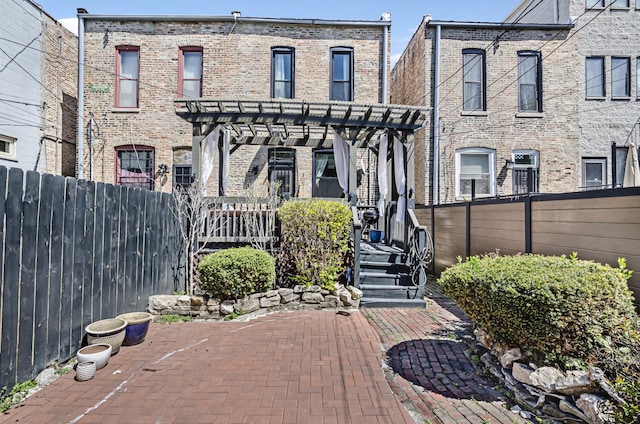 4738 S Champlain Ave, Chicago, IL 60615 - back of property with a pergola, fence, brick siding, and a patio