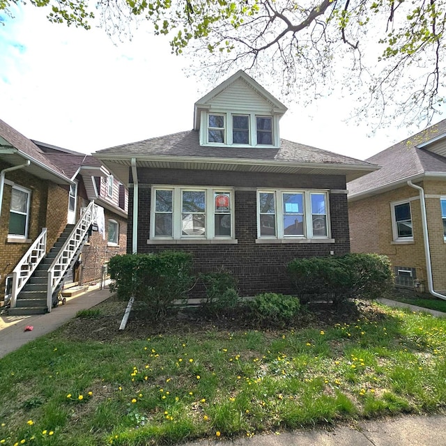 bungalow-style home with brick siding and stairway