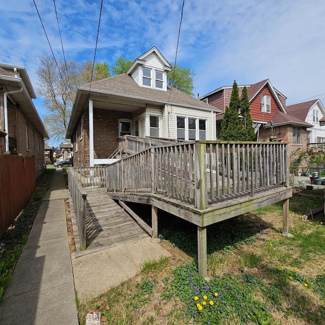 rear view of house featuring a wooden deck and brick siding