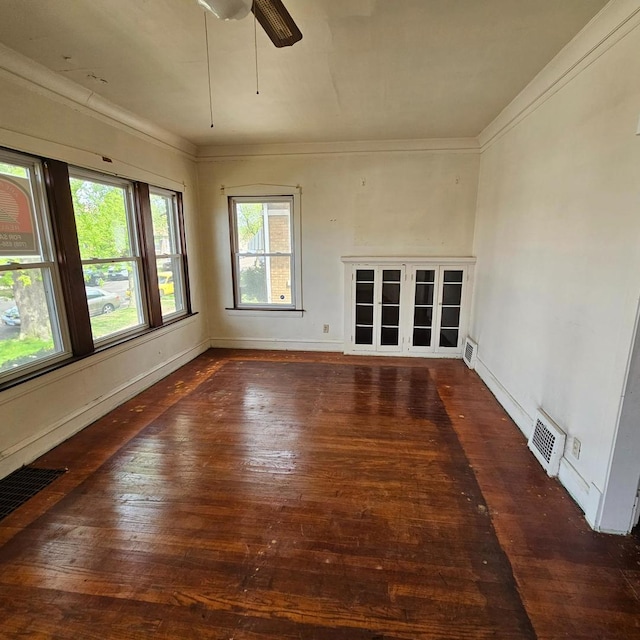 unfurnished room with hardwood / wood-style floors, a ceiling fan, ornamental molding, and baseboards