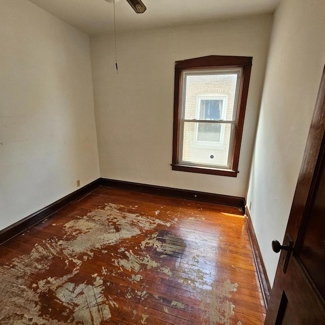 empty room with hardwood / wood-style floors, baseboards, and a ceiling fan