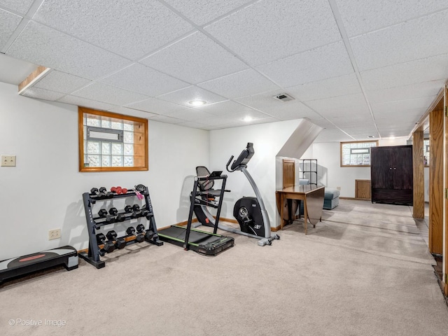 workout room with carpet flooring, a paneled ceiling, and baseboards