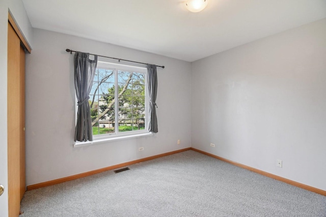 carpeted empty room with baseboards