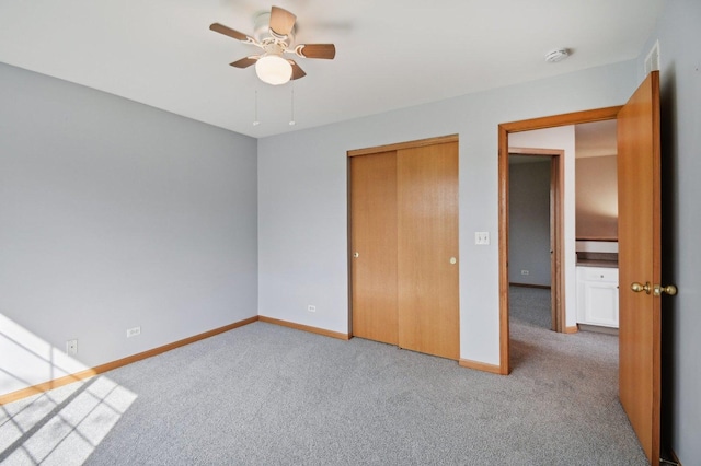 unfurnished bedroom with carpet, baseboards, a closet, and ceiling fan
