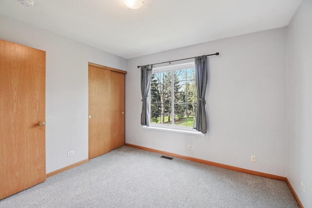unfurnished bedroom featuring carpet, baseboards, and a closet
