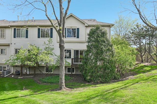 back of property featuring central AC and a yard