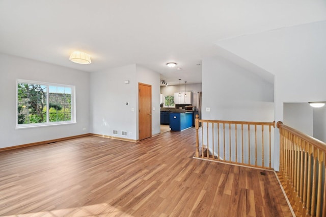 unfurnished room with light wood-type flooring and baseboards