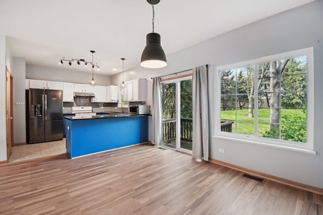 kitchen featuring black fridge with ice dispenser, light wood finished floors, a peninsula, white cabinets, and dark countertops
