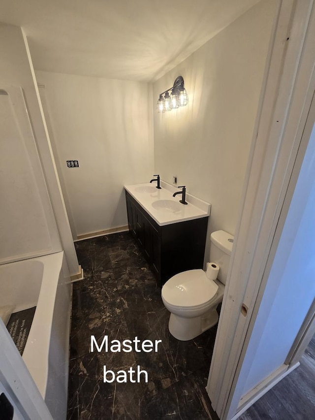 full bathroom with toilet, marble look tiles, and double vanity