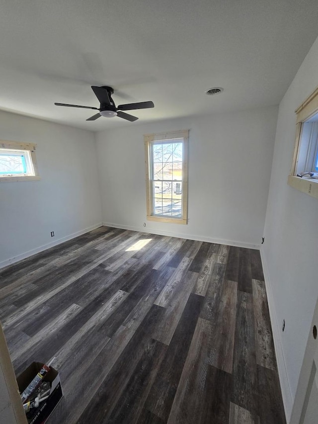 spare room featuring wood finished floors, baseboards, and a ceiling fan