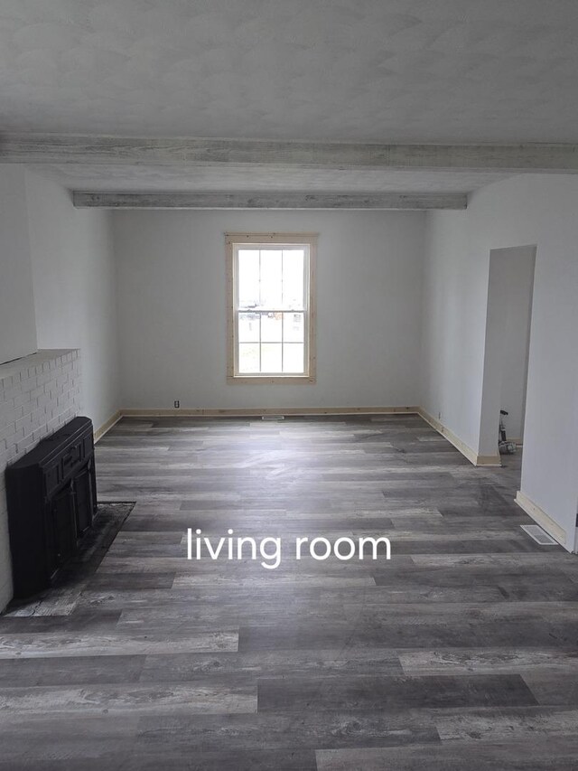 unfurnished living room with wood finished floors and baseboards