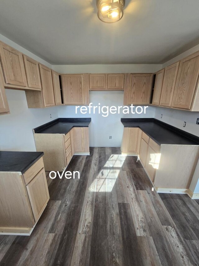 kitchen featuring light brown cabinets, dark wood-type flooring, and dark countertops