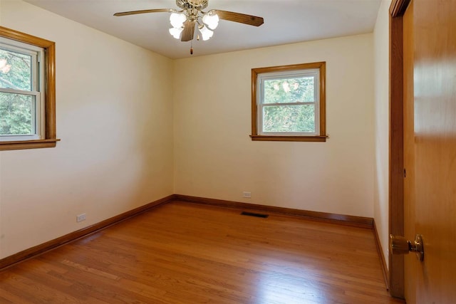 unfurnished room with plenty of natural light, light wood finished floors, and baseboards
