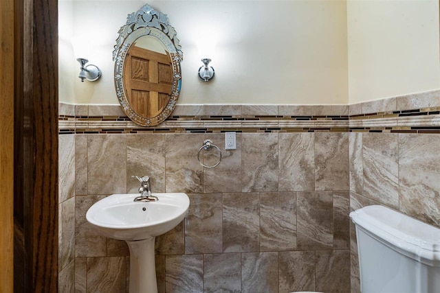 half bathroom with tile walls and toilet