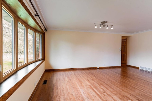unfurnished room featuring light wood-style floors, baseboards, and ornamental molding