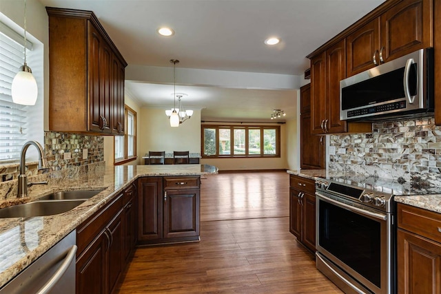 kitchen featuring stainless steel appliances, a sink, plenty of natural light, open floor plan, and recessed lighting