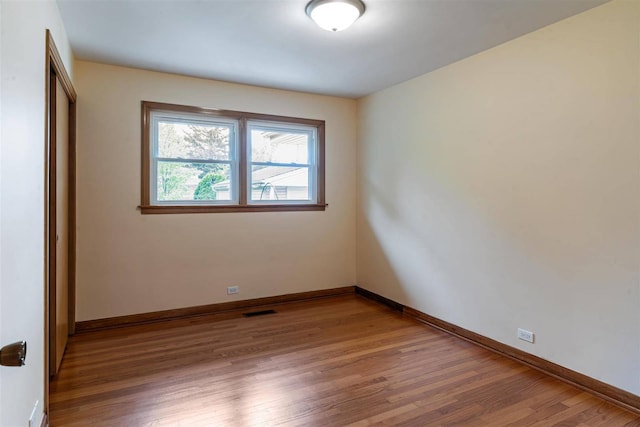 unfurnished room featuring wood finished floors and baseboards