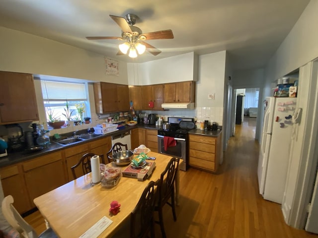 2552 N Austin Ave, Chicago, IL 60639 - kitchen with white appliances, under cabinet range hood, a sink, decorative backsplash, and dark countertops