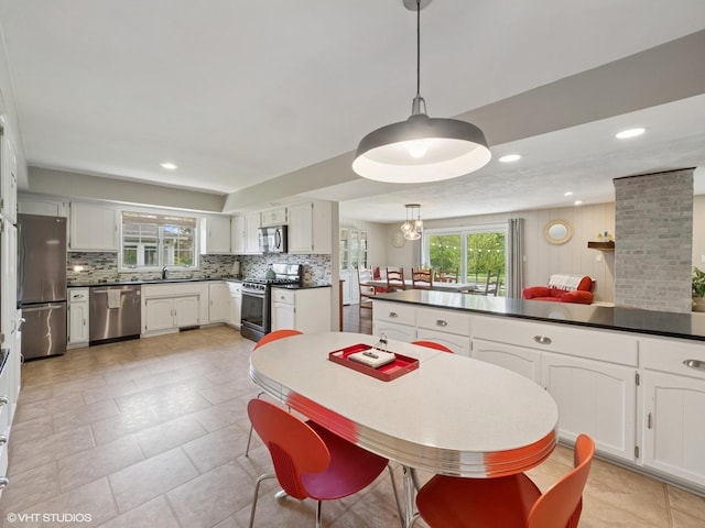 720 Ruskin Dr, Elk Grove Village, IL 60007 - kitchen featuring stainless steel appliances, backsplash, dark countertops, white cabinets, and a sink