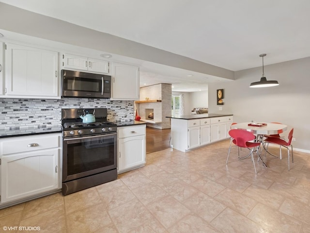 720 Ruskin Dr, Elk Grove Village, IL 60007 - kitchen featuring stainless steel appliances, dark countertops, white cabinets, and tasteful backsplash