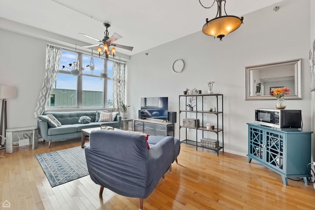 living area with wood-type flooring and ceiling fan
