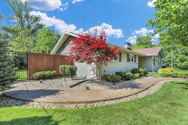 811 Hamilton Dr, Champaign, IL 61820 - view of home's exterior with brick siding, a chimney, and a gate