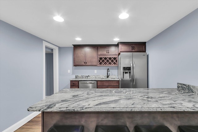 811 Hamilton Dr, Champaign, IL 61820 - kitchen with stainless steel appliances, a sink, a kitchen breakfast bar, light stone counters, and recessed lighting