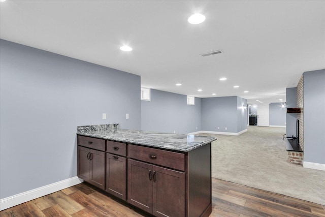 811 Hamilton Dr, Champaign, IL 61820 - kitchen featuring a peninsula, baseboards, light stone countertops, dark brown cabinetry, and recessed lighting