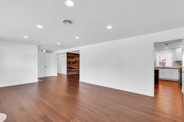 811 Hamilton Dr, Champaign, IL 61820 - unfurnished living room with dark wood-style flooring, recessed lighting, a sink, and baseboards