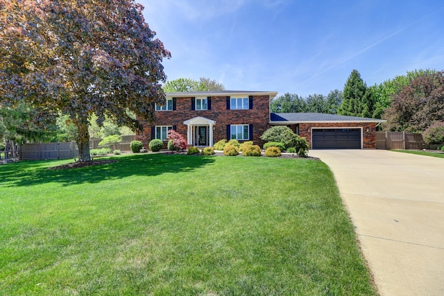 colonial house featuring a garage, driveway, and brick siding