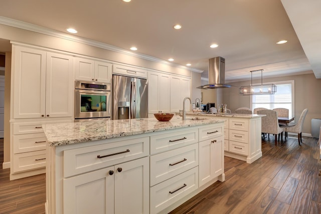 kitchen featuring appliances with stainless steel finishes, island exhaust hood, a sink, ornamental molding, and a center island