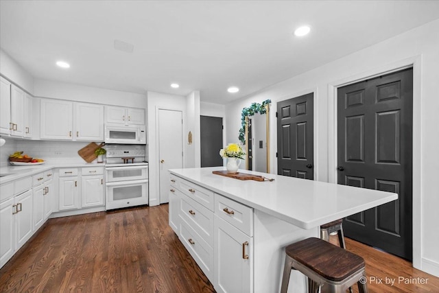 3121 Paris Ave Unit 304, River Grove, IL 60171 - kitchen featuring white appliances, a breakfast bar area, light countertops, white cabinets, and dark wood-style floors