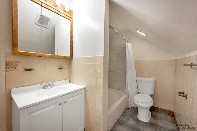 337 George Ave, Waukegan, IL 60085 - full bathroom with tile walls, toilet, vanity, lofted ceiling, and tile patterned flooring
