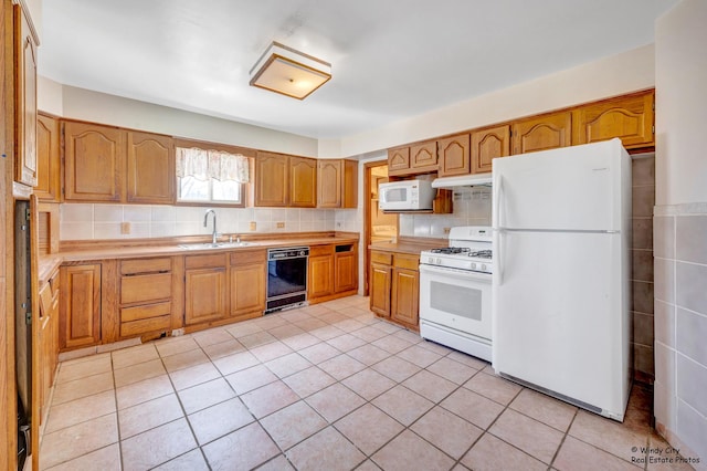 337 George Ave, Waukegan, IL 60085 - kitchen featuring white appliances, a sink, light countertops, under cabinet range hood, and light tile patterned floors