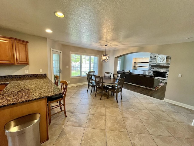 1143 N Westshore Blvd, Manteno, IL 60950 - dining room featuring recessed lighting, a textured ceiling, baseboards, light tile patterned floors, and a fireplace