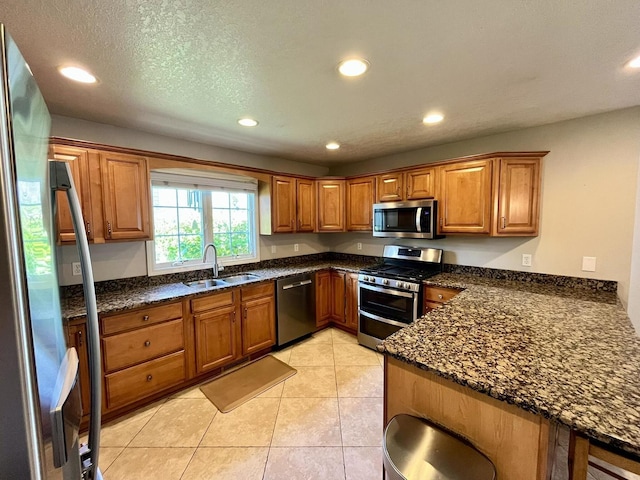 1143 N Westshore Blvd, Manteno, IL 60950 - kitchen featuring appliances with stainless steel finishes, a sink, recessed lighting, brown cabinetry, and dark stone counters