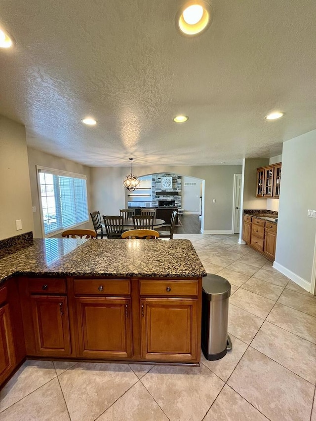 1143 N Westshore Blvd, Manteno, IL 60950 - kitchen with a textured ceiling, brown cabinets, recessed lighting, dark stone counters, and baseboards