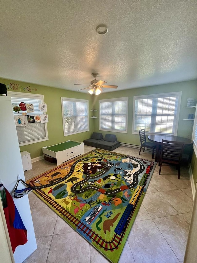 1143 N Westshore Blvd, Manteno, IL 60950 - playroom featuring a textured ceiling, light tile patterned floors, baseboards, and ceiling fan