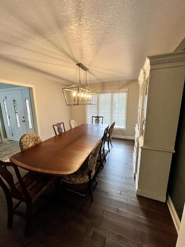1143 N Westshore Blvd, Manteno, IL 60950 - dining space with dark wood-type flooring, a textured ceiling, baseboards, and a chandelier
