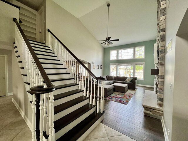 1143 N Westshore Blvd, Manteno, IL 60950 - stairway featuring ceiling fan, high vaulted ceiling, baseboards, and a stone fireplace