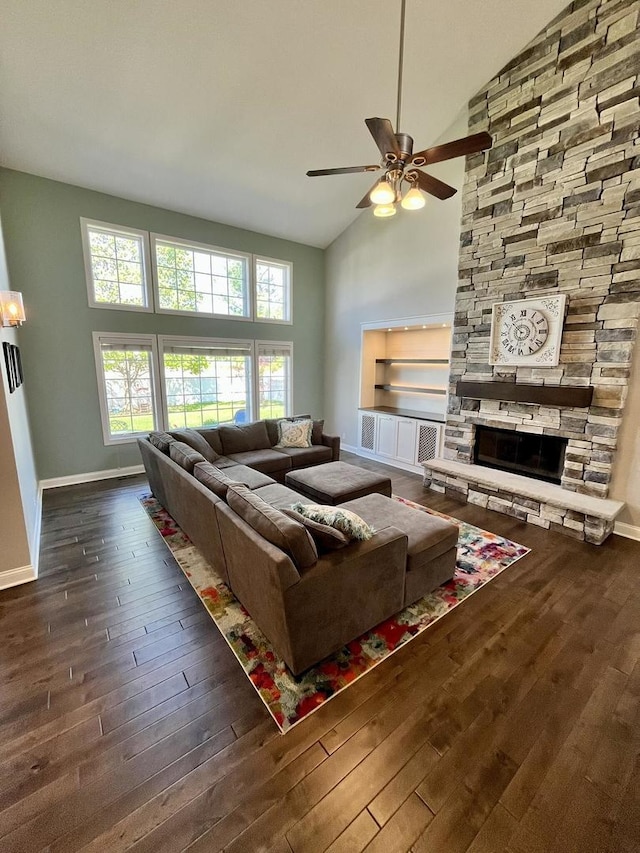 1143 N Westshore Blvd, Manteno, IL 60950 - living room featuring a ceiling fan, wood-type flooring, high vaulted ceiling, a stone fireplace, and baseboards