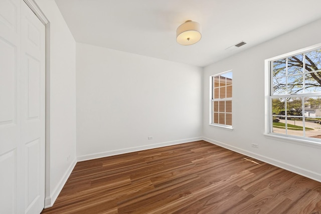 spare room with wood finished floors and baseboards