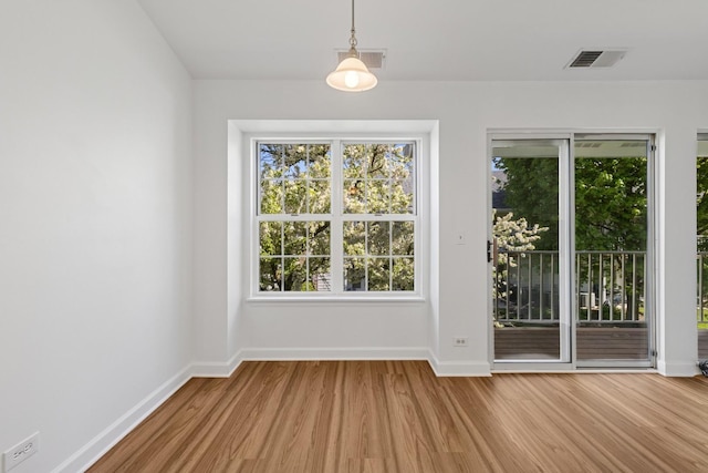 doorway featuring wood finished floors, plenty of natural light, and baseboards