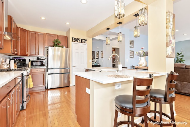 3123 Concord Ln, Wadsworth, IL 60083 - kitchen featuring stainless steel appliances, brown cabinetry, light wood-type flooring, a sink, and recessed lighting