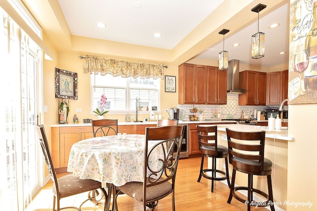 3123 Concord Ln, Wadsworth, IL 60083 - kitchen with wall chimney exhaust hood, light wood-style flooring, light countertops, decorative backsplash, and brown cabinetry