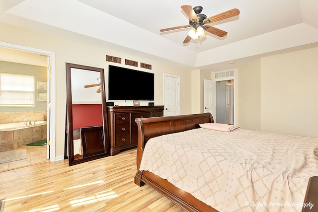 3123 Concord Ln, Wadsworth, IL 60083 - bedroom featuring light wood-type flooring, connected bathroom, a tray ceiling, and a ceiling fan