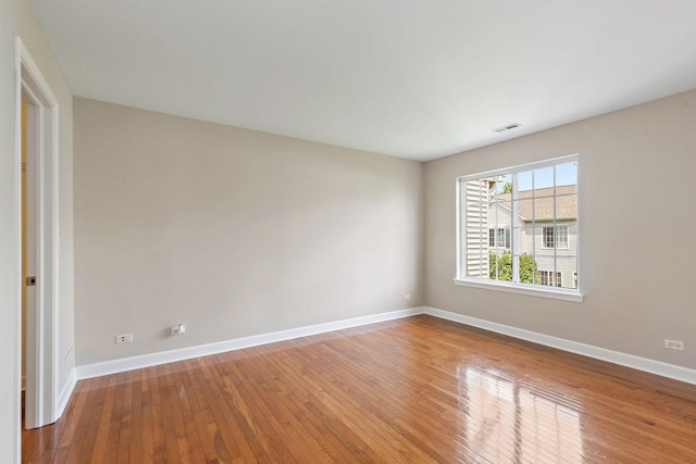 empty room featuring baseboards and hardwood / wood-style floors