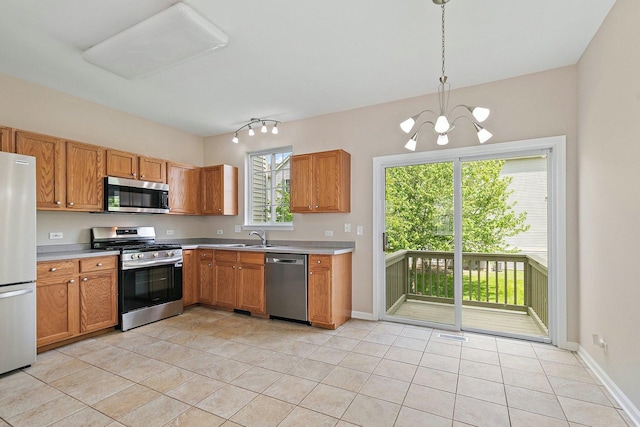 kitchen with appliances with stainless steel finishes, light countertops, light tile patterned floors, and a sink